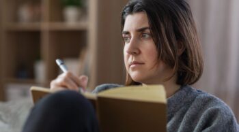 Veja 20 frases de conforto para pêsames e cura de quem mais ama. Mulher escrevendo palavras de apoio para expressar sentimentos em frases de conforto para pêsames.