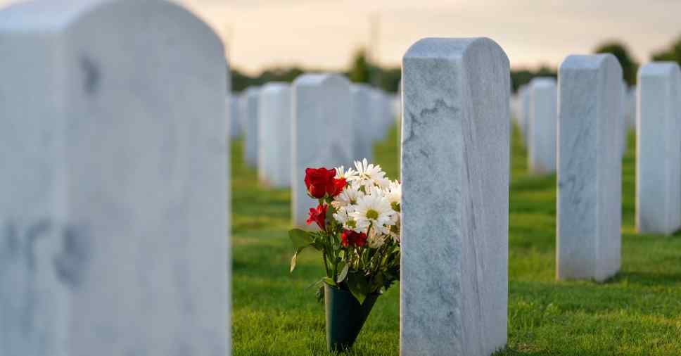 Visão aproximada de sepultura com flores para descrever as opções de jazigo perpétuo ou temporário